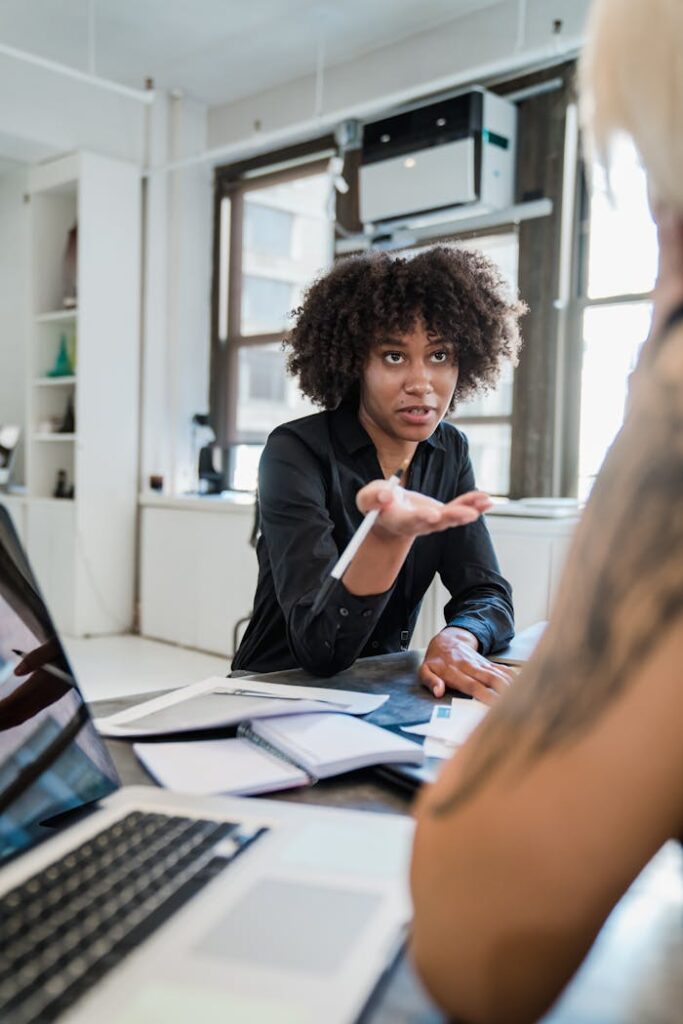 A professional woman engaged in a serious discussion inside a contemporary office environment.