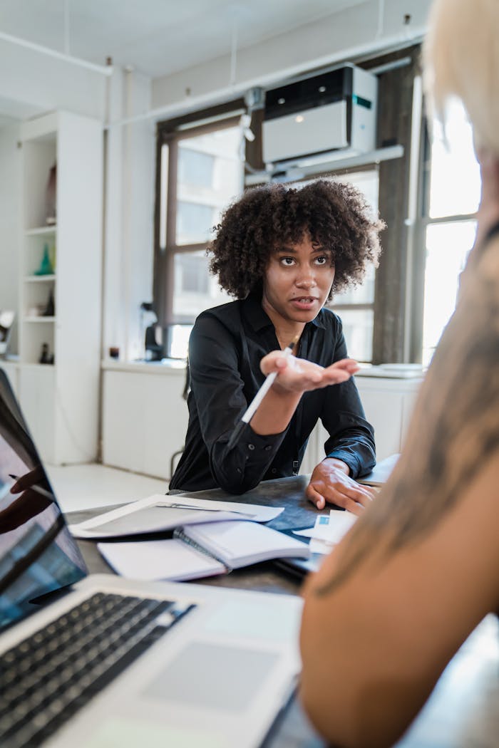 A professional woman engaged in a serious discussion inside a contemporary office environment.
