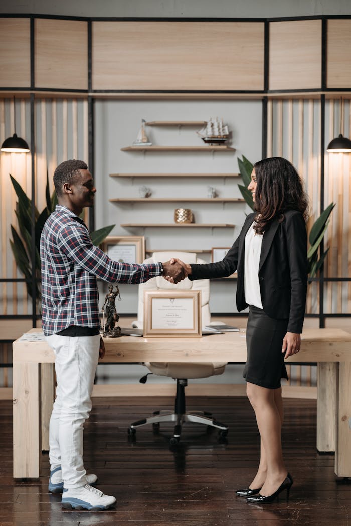 Professional handshake between colleagues in a stylish, modern office setting.